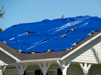 A plastic tarp covers this home's roof after a storm damaged it