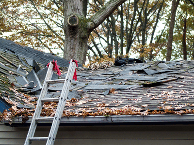 A ladder sits propped against this home so roofers can remove damaged shingles after a Fall storm
