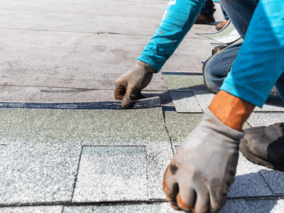 Professional roofer repairing damaged roof shingles