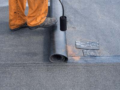 Roofer heating underlayment to help waterproof the roof